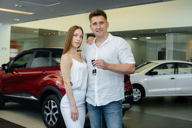 A happy young couple chooses a new car