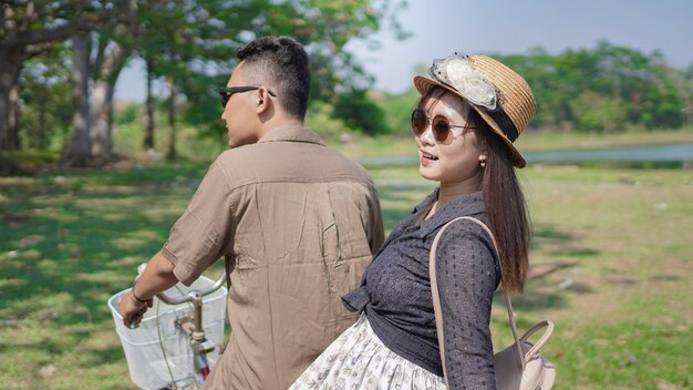 Happy young couple cycling in park at summer