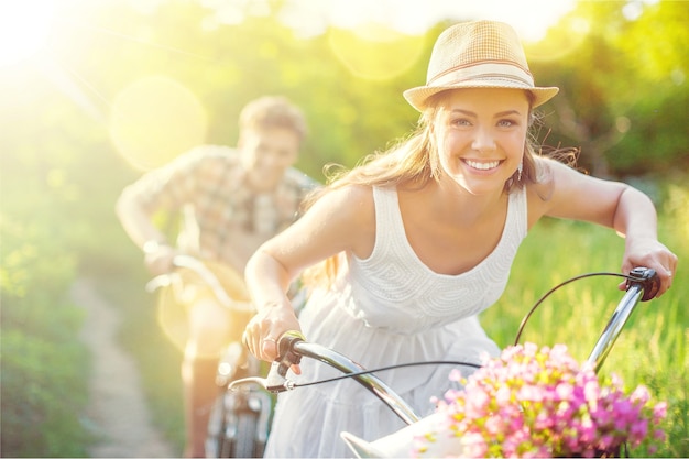 Happy young couple cycling through the park