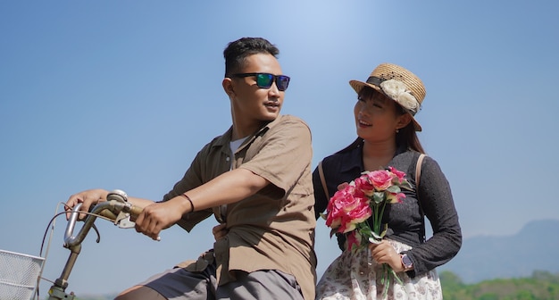 夏の青い空とサイクリング幸せな若いカップル