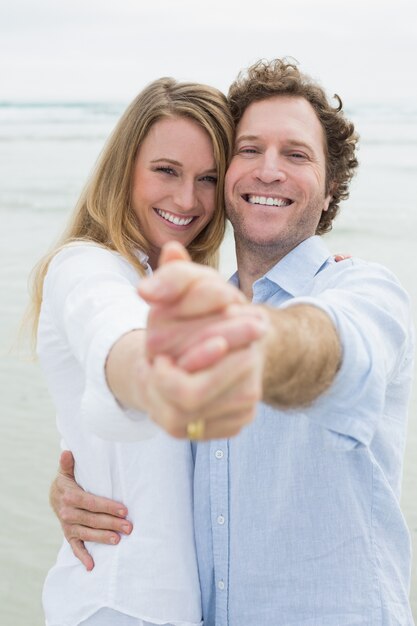 Happy young couple dancing at beach