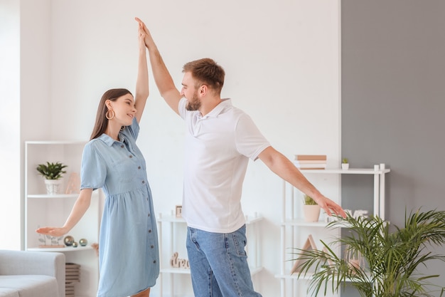 Happy young couple dancing at home