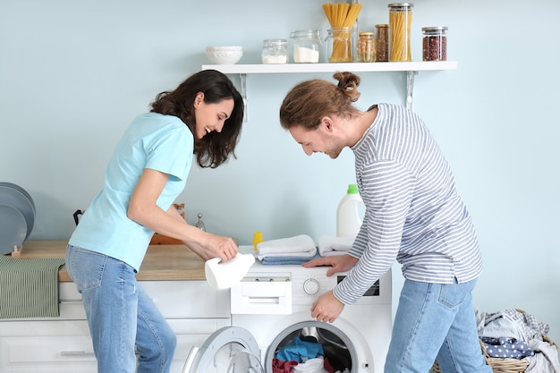 家で洗濯をしている幸せな若いカップル