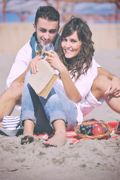해변에서 피크닉을 즐기고 여름 방학에 좋은 시간을 보내는 행복한 젊은 커플