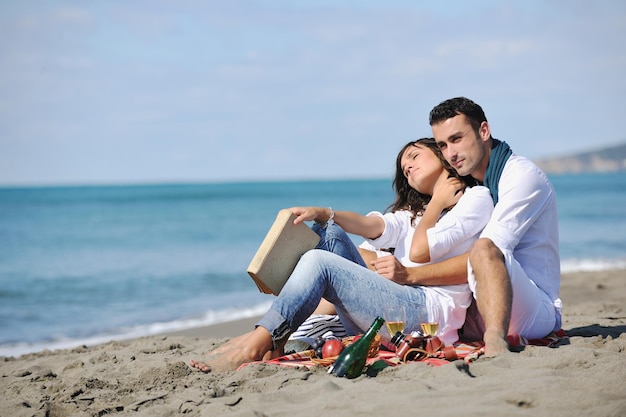 happy young couple enjoying  picnic on the beach and have good time on summer vacations