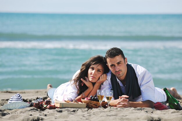 happy young couple enjoying  picnic on the beach and have good time on summer vacations