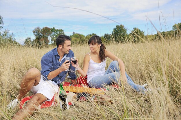 happy young couple enjoying  picnic on the countryside in the field  and have good time