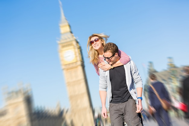 Happy young couple enjoying a piggyback ride in London