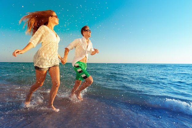 Photo happy young couple enjoying the sea