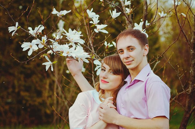 Happy young couple, family walking in spring park. Sunset. Family look. Lifestyle. Date. Love