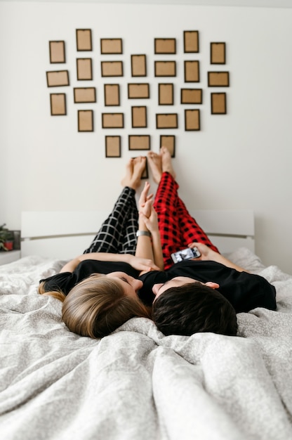 Happy young couple fooling around on the bed.