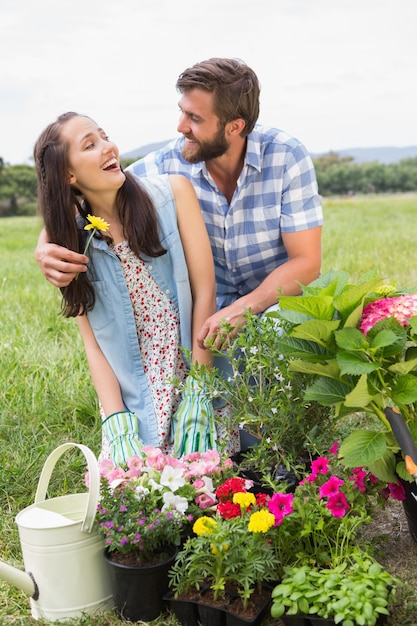 Foto giovani coppie felici che fanno il giardinaggio insieme