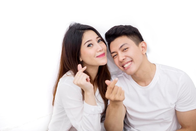 Happy young couple gesturing money on studio