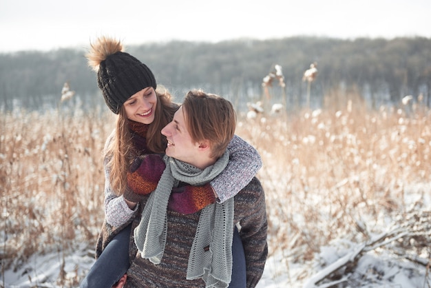 Happy young couple has fun on fresh snow at beautiful winter sunny day on vacation