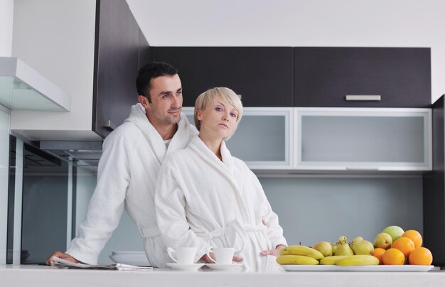 happy young couple have fun in  modern kitchen indoor  while preparing fresh fruits and vegetables food salad