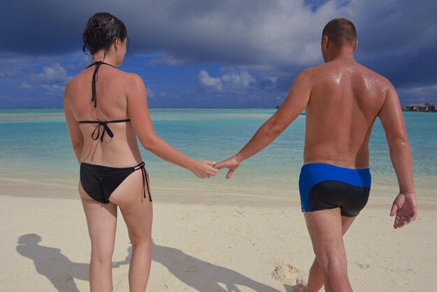 счастливая молодая пара развлекается и отдыхает на летних каникулах на фоне мальдивского путешествия и красивого пляжа с белым песком