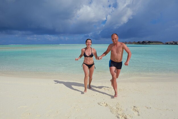 happy young couple have fun and relax at summer vacation on background maldives travel location and beautiful white sand beach