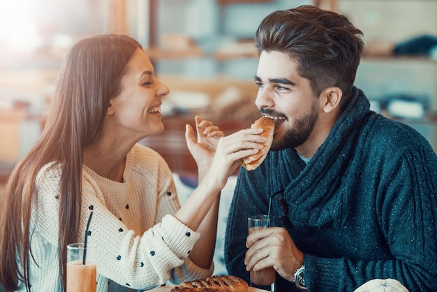 Happy young couple having breakfast in cafe