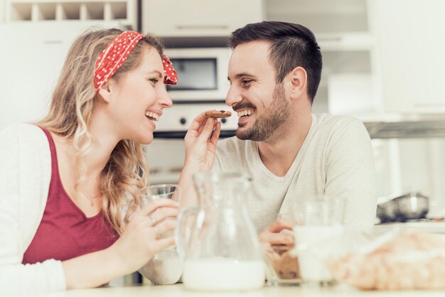 Foto giovani coppie felici che mangiano prima colazione a casa