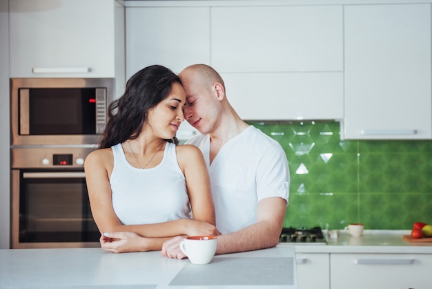 Happy young couple having coffee in the kitchen