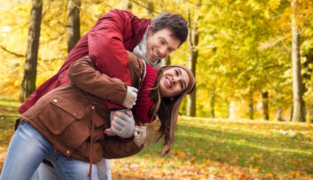 Foto una giovane coppia felice che si diverte nel parco d'autunno