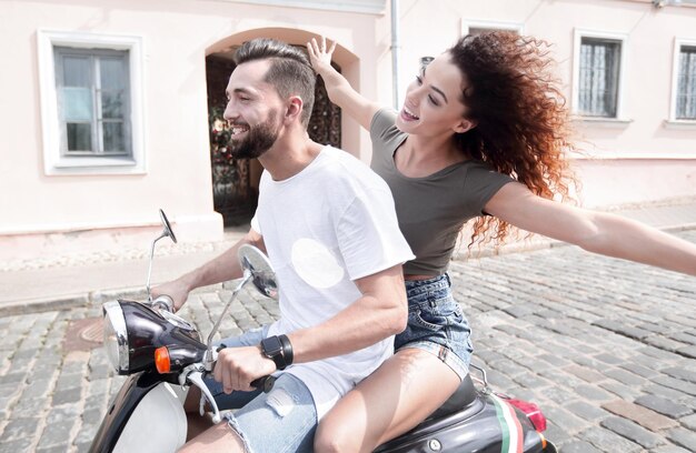 Giovani coppie felici divertendosi su uno scooter