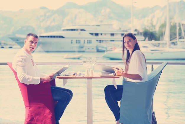 happy young couple having lanch at beautiful restaurant on by the sea on  beach