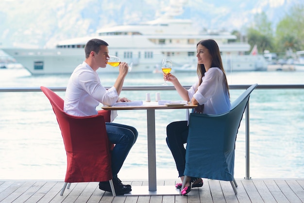 happy young couple having lanch at beautiful restaurant on by the sea on  beach