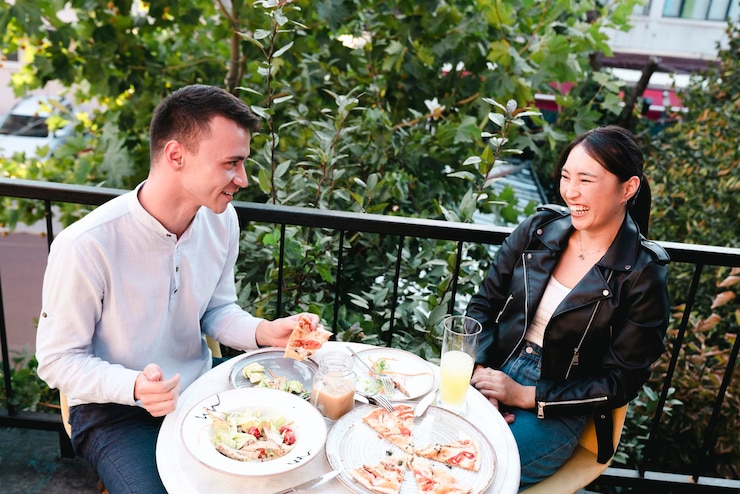 Photo 幸せな若いカップルが屋外レストランで昼食をとっている