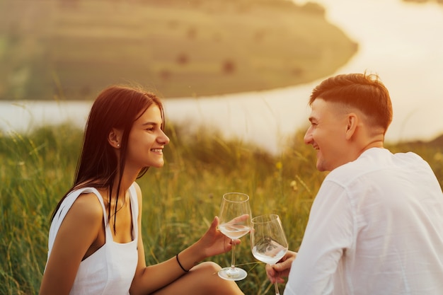 Happy young couple on the hill relaxing at the picnic.