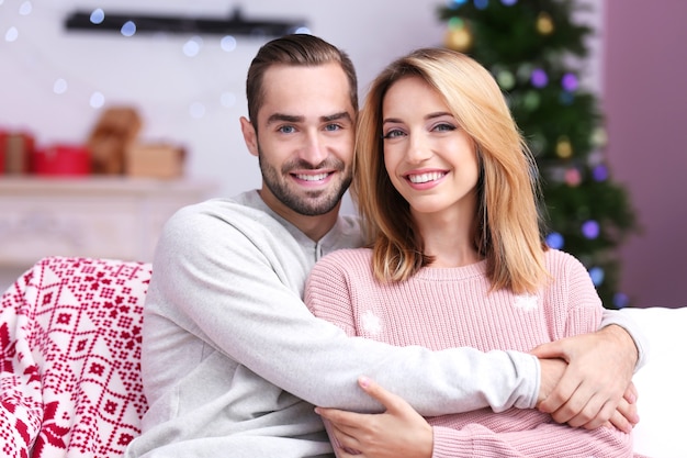 家で幸せな若いカップル。クリスマスのコンセプト
