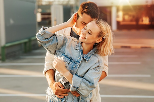 happy young couple hugging on city parking