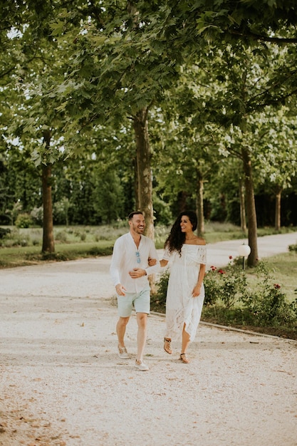 A happy young couple is enjoying the beautiful surroundings of a garden basking in the sun and each other's company