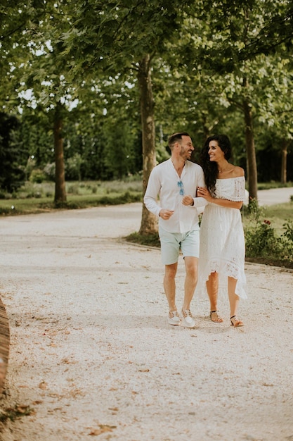 Una giovane coppia felice si sta godendo i bellissimi dintorni di un giardino crogiolandosi al sole e in reciproca compagnia