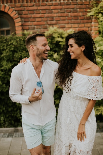 A happy young couple is enjoying the beautiful surroundings of a garden basking in the sun and each other's company