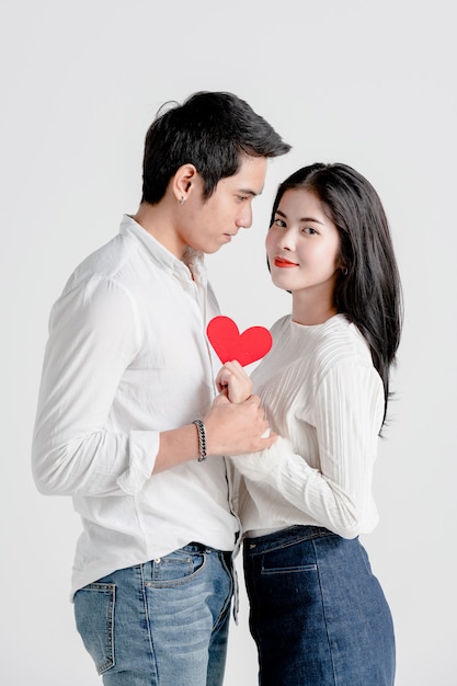 Happy young couple is holding red paper hearts 