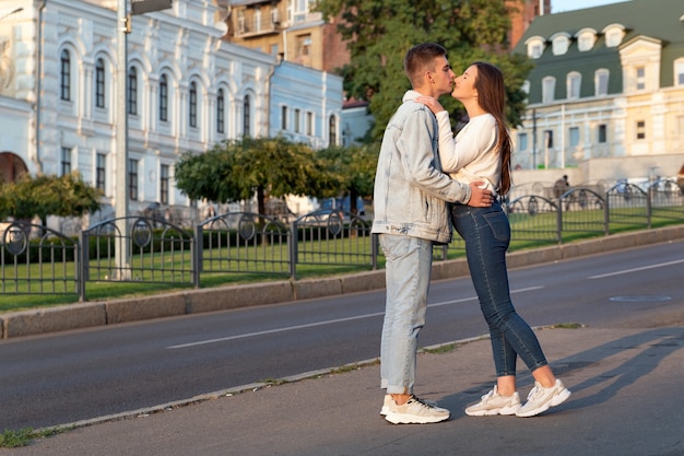 Фото Счастливая молодая пара, целующаяся на улице. нежность, любовь, забота.