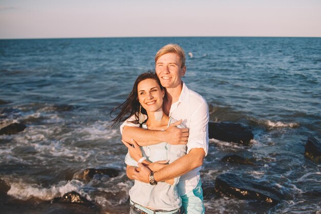 Happy young couple in love against the sea walk at beach against blue sky and have fun at summer day Togetherness love family