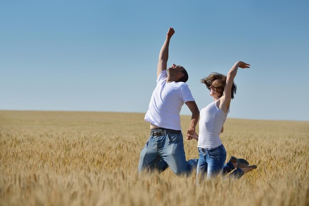 счастливая молодая влюбленная пара имеет романтику и веселье на пшеничном поле летом