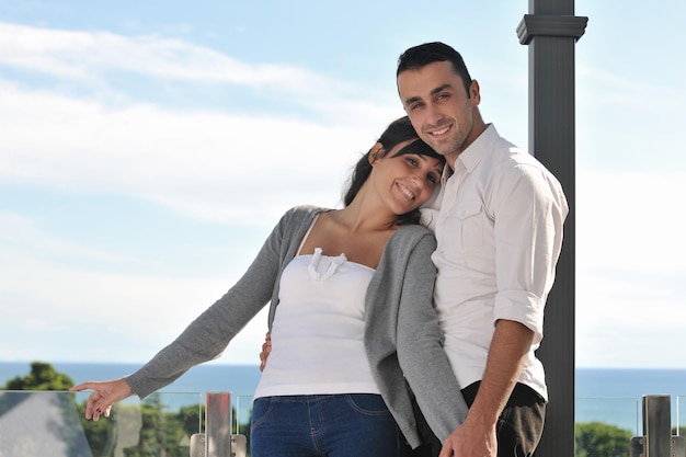 happy young couple in love have romance  relax on balcony outdoor with ocean and blue sky in background