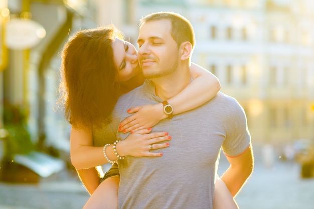 Happy young couple in love hugging at city