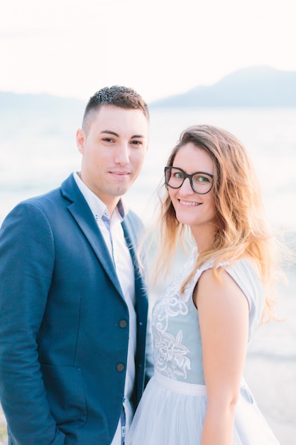 Happy young couple in love posing near the Garda Lake.