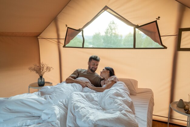 Happy young couple lying in bed after awakening in the morning