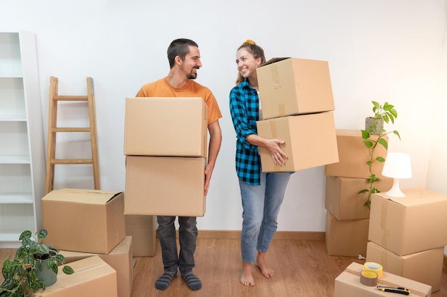 Happy young couple in the new house. Moving boxes. Stacked cardboard boxes. Rental apartment.