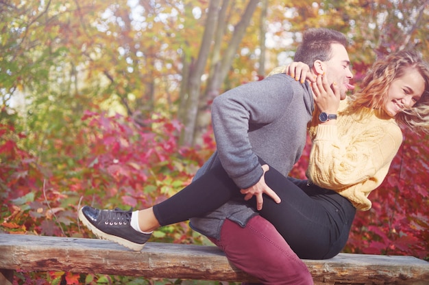 Happy young couple outdoors on a beautiful autumn day in the forest