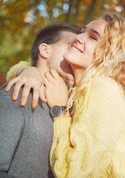 Happy young couple outdoors on a beautiful autumn day in the forest