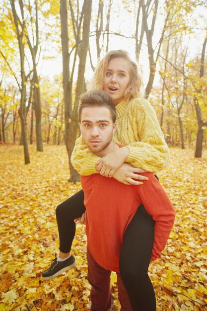 Happy young couple outdoors on a beautiful autumn day in the forest