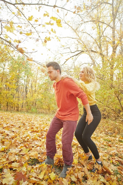 Happy young couple outdoors on a beautiful autumn day in the forest