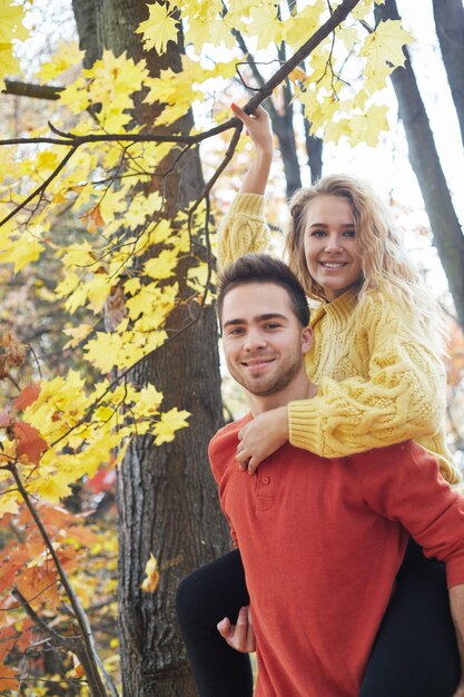 Happy young couple outdoors on a beautiful autumn day in the forest