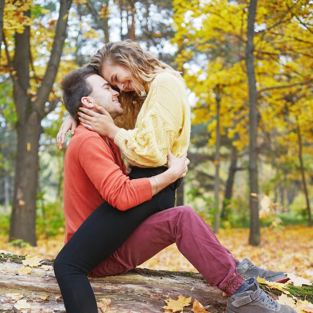 Happy young couple outdoors on a beautiful autumn day in the forest